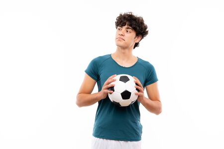 Young football player man over isolated white wall making doubts gesture while lifting the shouldersの写真素材