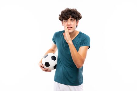 Young football player man over isolated white wall whispering somethingの写真素材