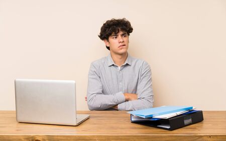 Young student man with a laptop with confuse face expressionの写真素材