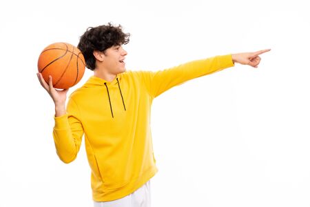 Young basketball player man over isolated white wallの写真素材
