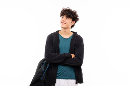 Sport man over isolated white background looking up while smilingの写真素材