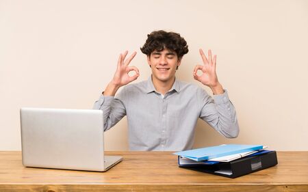 Young student man with a laptop in zen poseの写真素材