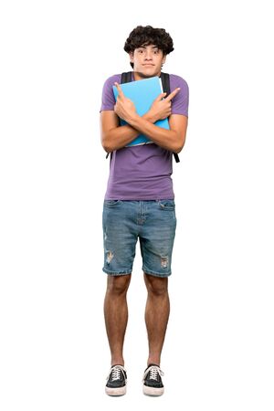 A full-length shot of a Young student man pointing to the laterals having doubts over isolated white backgroundの写真素材