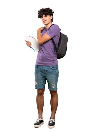 A full-length shot of a Young student man suffering from pain in shoulder for having made an effort over isolated white backgroundの写真素材