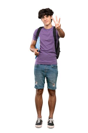 A full-length shot of a Young student man happy and counting three with fingers over isolated white backgroundの写真素材