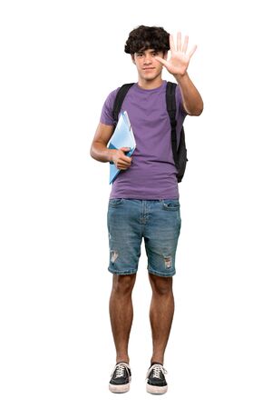 A full-length shot of a Young student man counting five with fingers over isolated white backgroundの写真素材