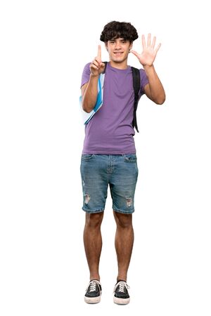 A full-length shot of a Young student man counting six with fingers over isolated white backgroundの写真素材