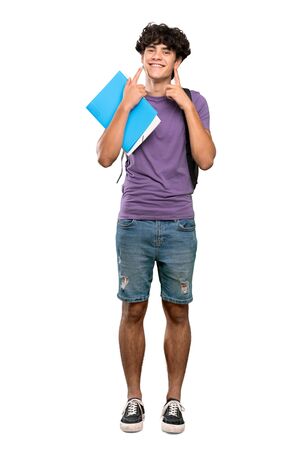 A full-length shot of a Young student man smiling with a happy and pleasant expression over isolated white backgroundの写真素材