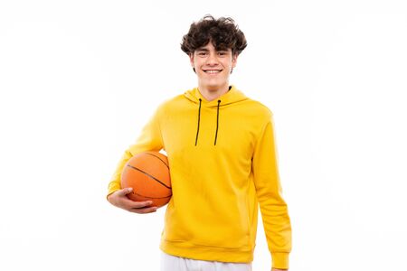 Young basketball player man over isolated white wall smiling a lotの写真素材