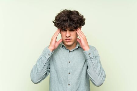 Young man over isolated green wall unhappy and frustrated with something. Negative facial expressionの写真素材