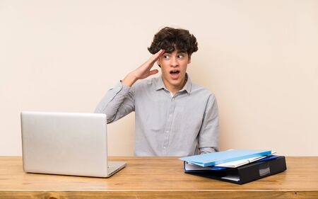 Young student man with a laptop has just realized something and has intending the solutionの写真素材