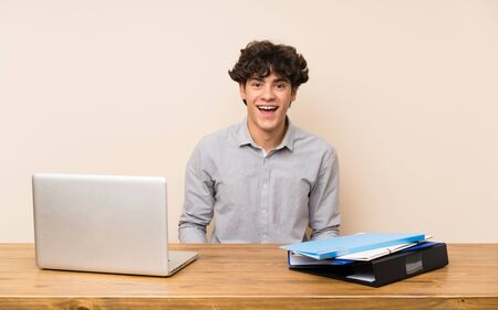 Young student man with a laptop with surprise facial expressionの写真素材