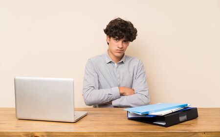 Young student man with a laptop feeling upsetの写真素材