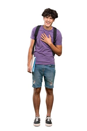 A full-length shot of a Young student man smiling a lot over isolated white backgroundの写真素材