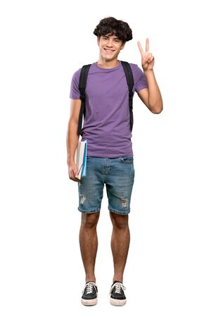 A full-length shot of a Young student man showing victory sign with both hands over isolated white backgroundの写真素材