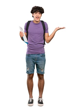 A full-length shot of a Young student man with shocked facial expression over isolated white backgroundの写真素材
