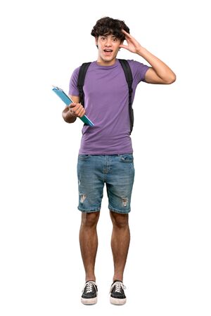 A full-length shot of a Young student man with surprise expression over isolated white backgroundの写真素材