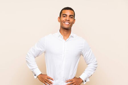 Young handsome brunette man over isolated background posing with arms at hip and smilingの写真素材