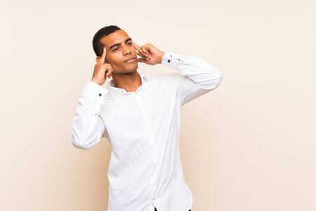 Young handsome brunette man over isolated background having doubts and thinkingの写真素材
