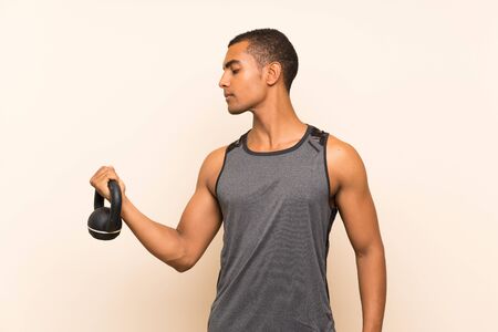 Sport man over isolated background with kettlebellの写真素材