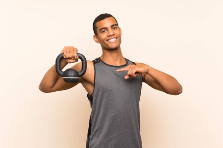 Sport man over isolated background with kettlebellの写真素材