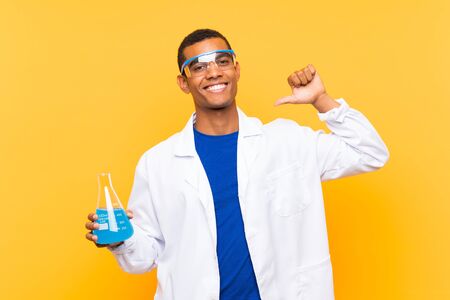 Scientific man holding a laboratory flask over isolated background proud and self-satisfiedの写真素材