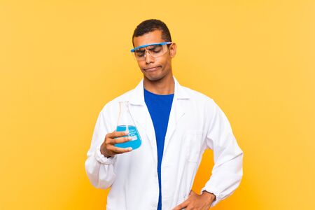 Scientific man holding a laboratory flask over isolated background with sad expressionの写真素材