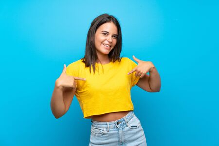 Young girl over isolated blue background proud and self-satisfiedの写真素材