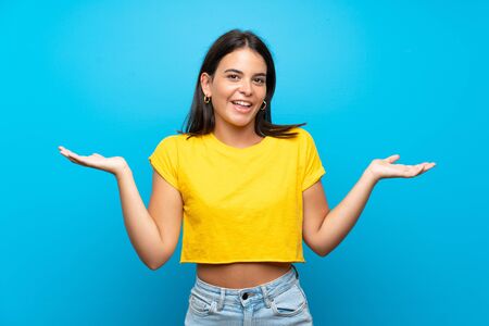Young girl over isolated blue background with shocked facial expressionの写真素材