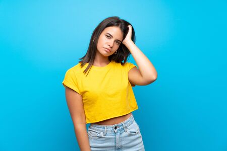 Young girl over isolated blue background with an expression of frustration and not understandingの写真素材