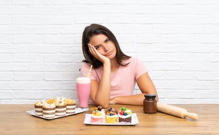 Young girl with lots of different cakesの写真素材