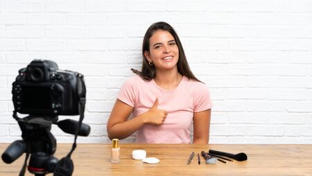 Young girl recording a video tutorial giving a thumbs up gestureの写真素材