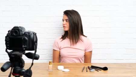 Young girl recording a video tutorial looking sideの写真素材