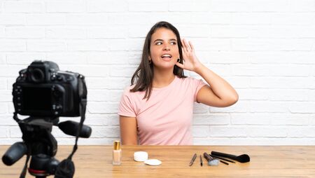 Young girl recording a video tutorial listening somethingの写真素材