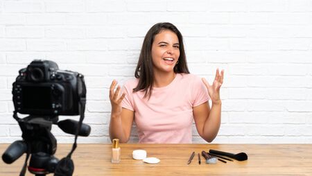Young girl recording a video tutorial unhappy and frustrated with somethingの写真素材