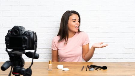 Young girl recording a video tutorial holding copyspace imaginary on the palmの写真素材