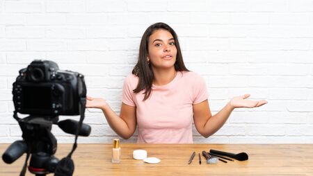 Young girl recording a video tutorial having doubts with confuse face expressionの写真素材