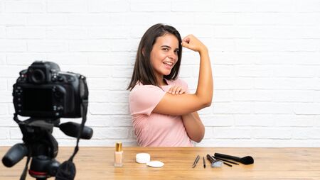 Young girl recording a video tutorial making strong gestureの写真素材