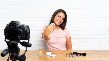 Young girl recording a video tutorial inviting to comeの写真素材