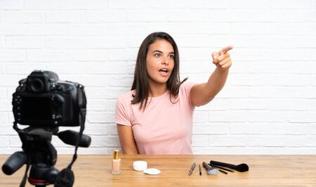 Young girl recording a video tutorial pointing awayの写真素材