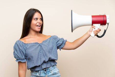 Young girl over isolated background holding a megaphoneの写真素材