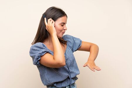 Young girl over isolated background listening to music with headphonesの写真素材