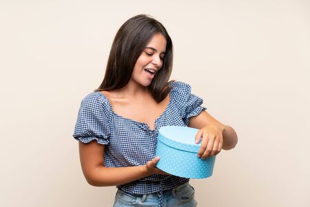 Young girl over isolated background holding gift boxの写真素材