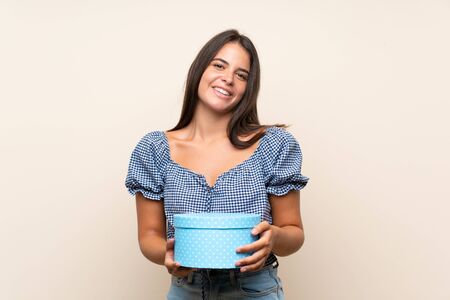 Young girl over isolated background holding gift boxの写真素材