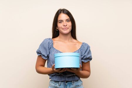 Young girl over isolated background holding gift boxの写真素材