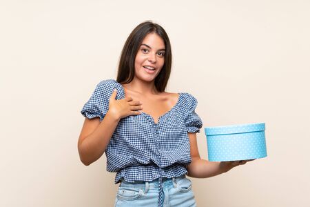 Young girl over isolated background holding gift boxの写真素材