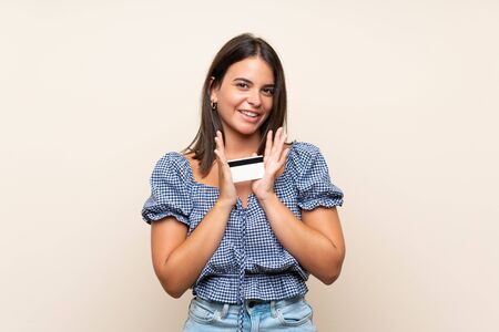 Young girl over isolated background holding a credit cardの写真素材