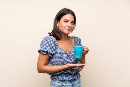 Young girl over isolated background holding hot cup of coffeeの写真素材