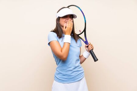Young woman playing tennis over isolated background smiling a lotの写真素材