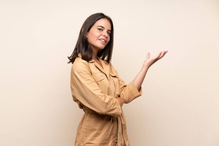 Young girl over isolated background extending hands to the side for inviting to comeの写真素材
